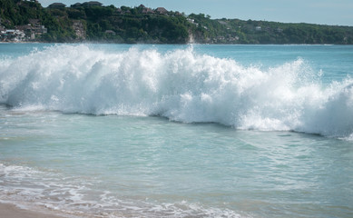 Große Welle bricht am Strand