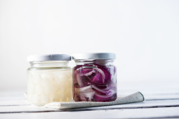 Glass Jar of Pickled Onions on White wood Background