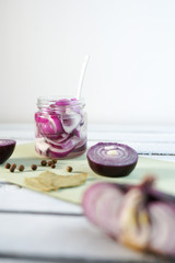 Glass Jar of Pickled Onions on White wood Background