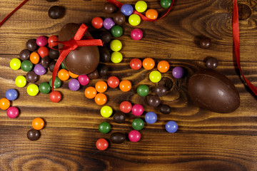 Easter composition with chocolate eggs on wooden background