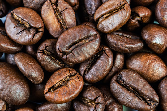 Coffee beans close up. Macro photo. The image is suitable as a background for a coffee house, on the subject of making coffee.