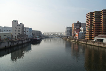 Fototapeta na wymiar Cityscape with river, bridges and buildings in Osaka in spring clear day