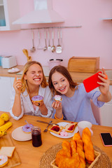 Sisters with whipped cream on noses making photos for memory