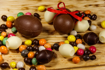 Easter composition with chocolate eggs on wooden background