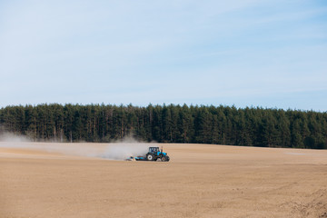 Tractor plows a field in spring