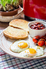 Traditional English Breakfast - Eggs, Sausage, Tomato, Toasts, Beans