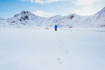 A man walks through the snow in Norway on the Lofoten Islands