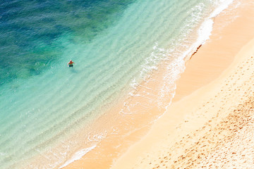 Hombre mayor dándose un baño en playa solitaria