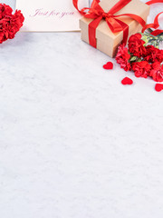 May mothers day handmade giftbox wishes photography - Beautiful blooming carnations with red ribbon bow box isolated on modern marble desk, close up, copy space, mock up