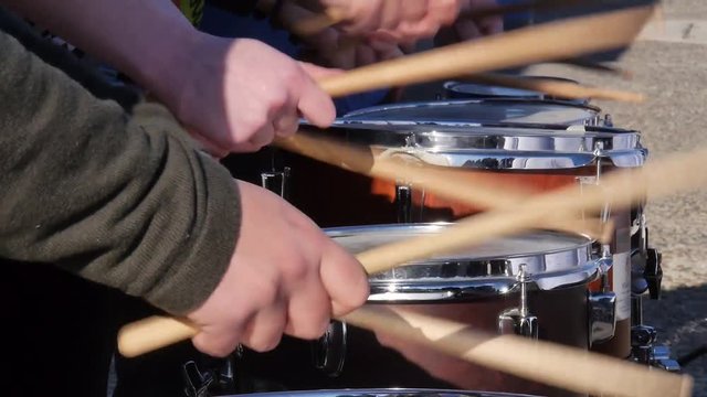Close-up of many drummers in a line playing in unison