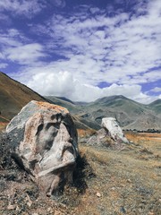 The meadow at the mountain foot in Sno village with the boulders with carved faces of famous...