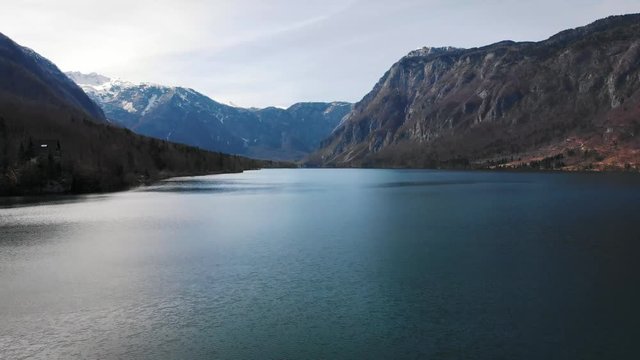 4K aerial footage of a lake in the alps with mountains and snow
