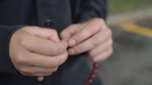 A woman counts beads on a rosary