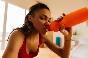 Young active woman feeling thirsty after intensive workout