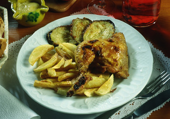 Un cuarto de pollo al grill con patatas y berenjenas fritas