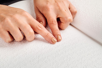 Finger read braille alphabet in white paper.