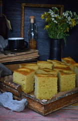 Homemade corn cake with tangerines on dark background. Traditional Brazilian sweet pie. Cornbread. Style Dark Moody.