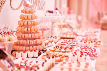 Delicious candy bar with cupcakes, macaroons and other sweets