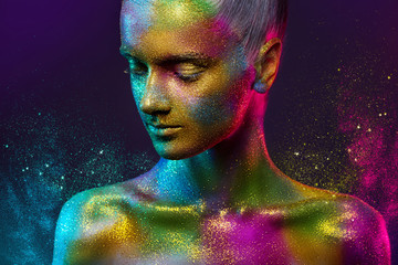 Beautiful girl in colorful bright sequins and colorful lights posing in the Studio . Art design colorful bright makeup