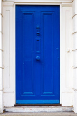 Bright blue house door seen in its entirety - an entire blue door in London, Britian