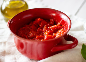 Chopped tomatoes with olive oil on a white background.