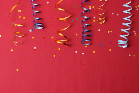  Festive background of ribbons and confetti on a colored background top view.