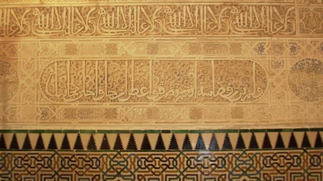 Close shot of an old arabic wall of the Alhambra with color tiles.