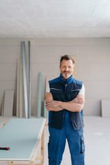 Confident handyman with folded arms