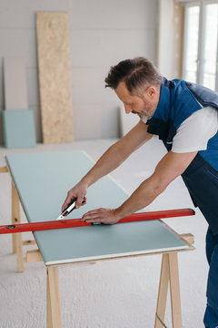 Builder using a spirit level as a ruler