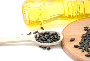 sunflower oil in a bottle and seeds on a wooden spoon