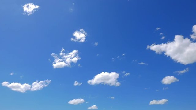 Fast passing white cloudlets on a bright blue sky background