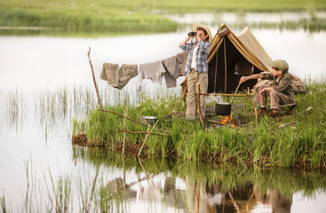 Two boys kindle a fire on the lake