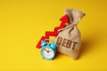 Taxes and interest on debt payments. Overdue payments, penalties. Bag with money and clock on yellow background. Red arrow up.