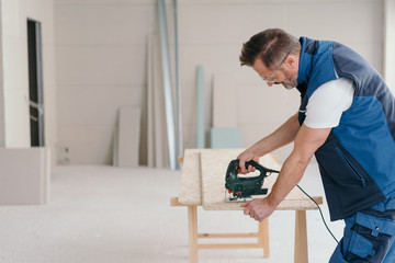 Handyman cutting a section of chip board