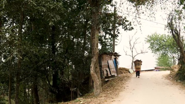 People carrying materials in a doko in rural Nepal.