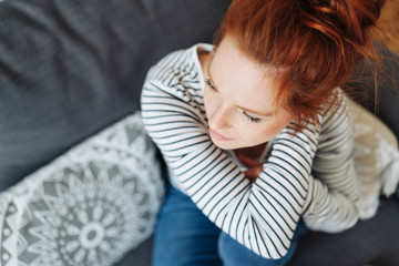Young redhead woman sitting thinking