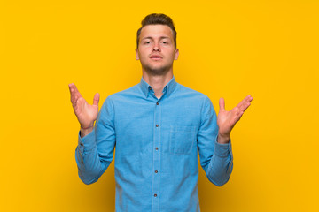 Fototapeta premium Blonde man over isolated yellow wall frustrated by a bad situation