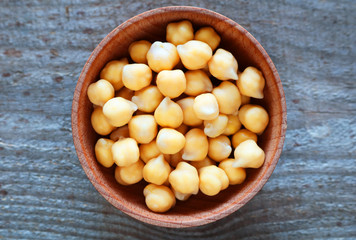 Chickpea grains lie in a round plate. Chickpeas contains a lot of protein. Selective focus 