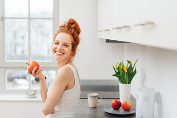 Happy healthy young woman eating fresh fruit