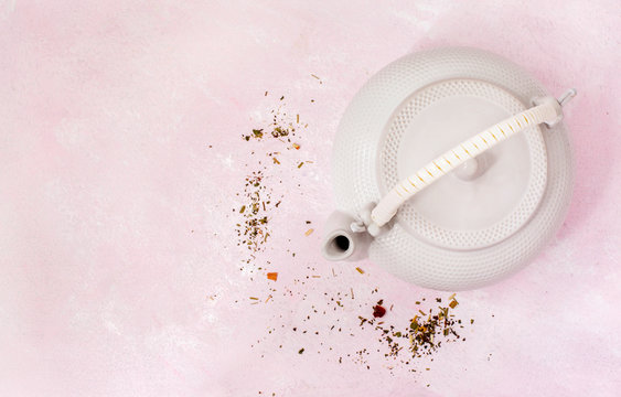 A white porcelain teapot on pink background