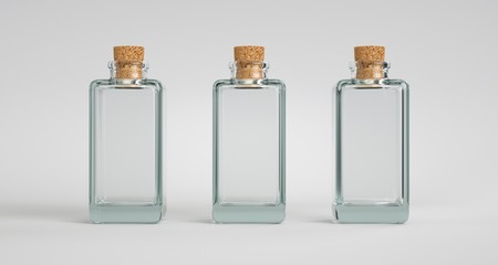 Three square glass containers with a cork stopper. Light background