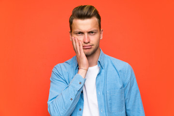 Obraz premium Blonde handsome man over isolated wall unhappy and frustrated