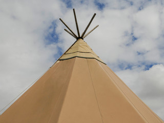 Top of teepee against clouds. Pyramid shape, American history.