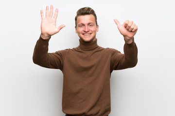 Fototapeta premium Blonde man over isolated white wall counting six with fingers