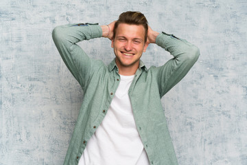 Blonde handsome man with green shirt laughing