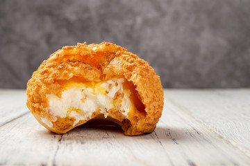 sweet puff with a bite on a white wood table