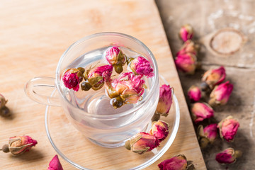 Herb tea with tea rose petals. Dry rose buds, tea cup