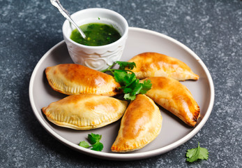 Empanadas with chimichurri sauce. Traditional Latin American cuisine.