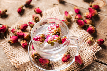 Herb tea with tea rose petals. Dry rose buds, tea cup