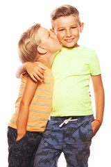 Mother's joy concept. Portrait of two funny siblings brothers posing for picture during family photo shooting: elder boy embraces his little friend. Happy faces, shiny smiles. Studio shot